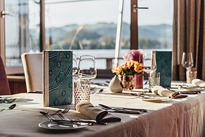 [Translate to Englisch:] Gedeckte Tafel im Restaurant Bootshaus mit Seeblick