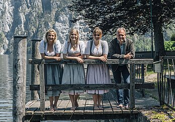 [Translate to Englisch:] Familie Gröller in Tracht am Steg